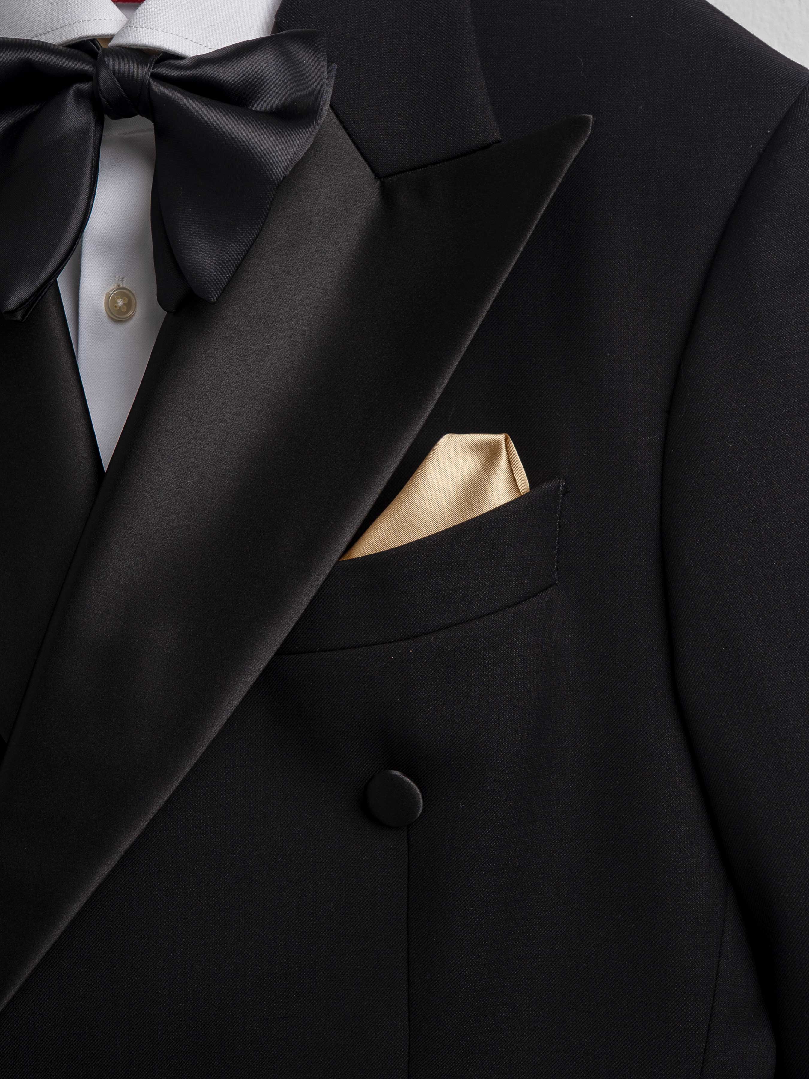 Black tuxedo with satin lapels, bow tie, and gold pocket square for formal events