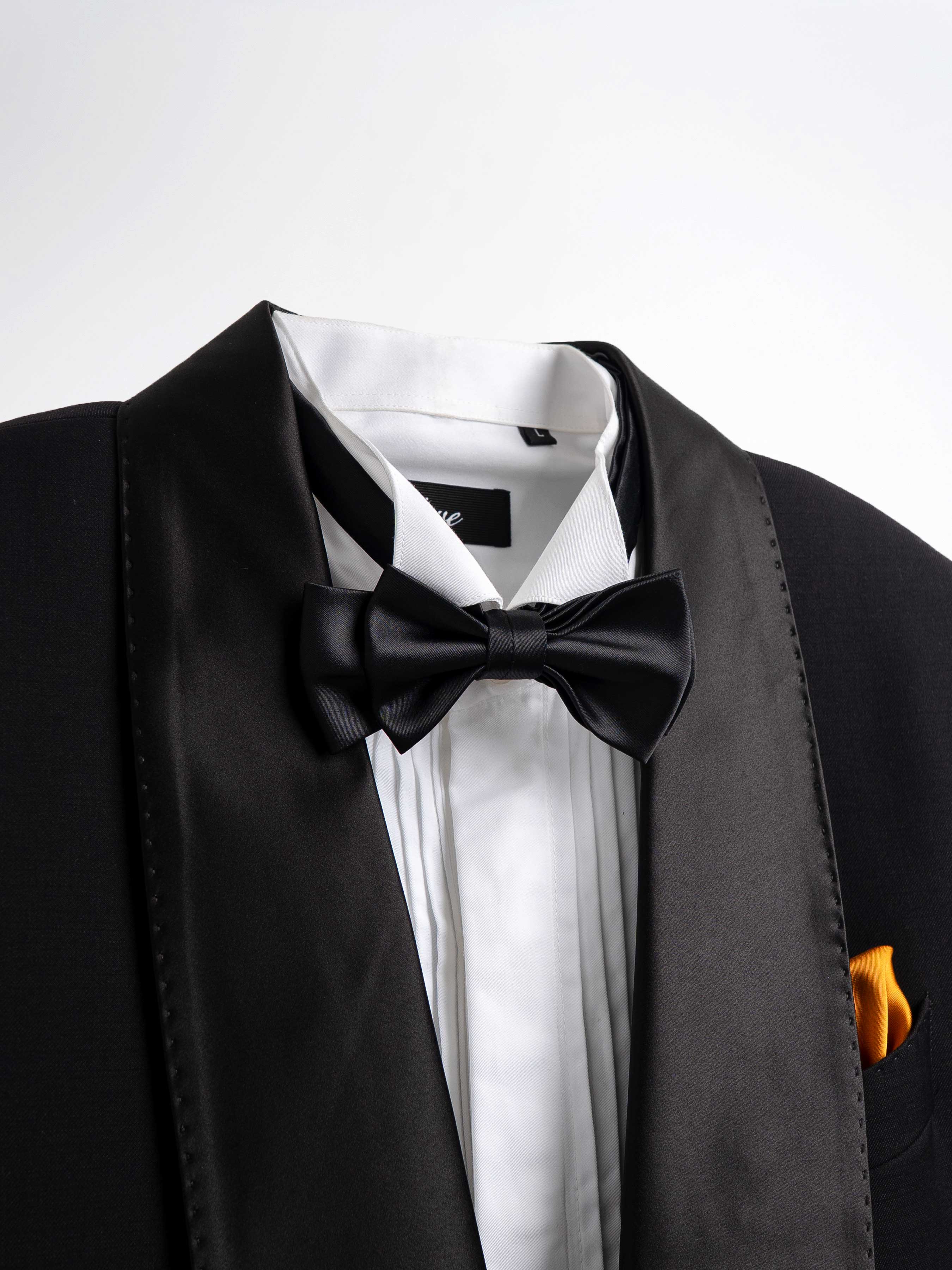 Black tuxedo with satin lapels, white dress shirt, black bow tie, and orange pocket square for formal events.