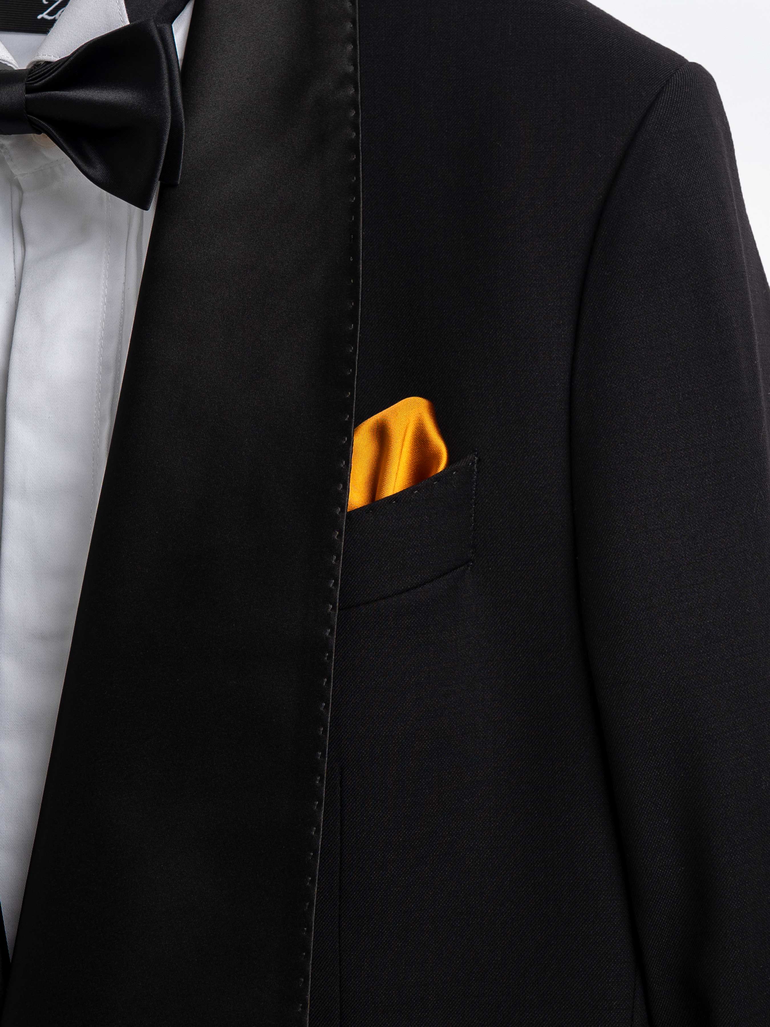 Black tuxedo jacket with satin lapel, bow tie, and gold pocket square for formal men's wear
