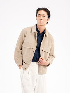 Men's beige corduroy jacket with navy shirt and white trousers, stylish casual wear