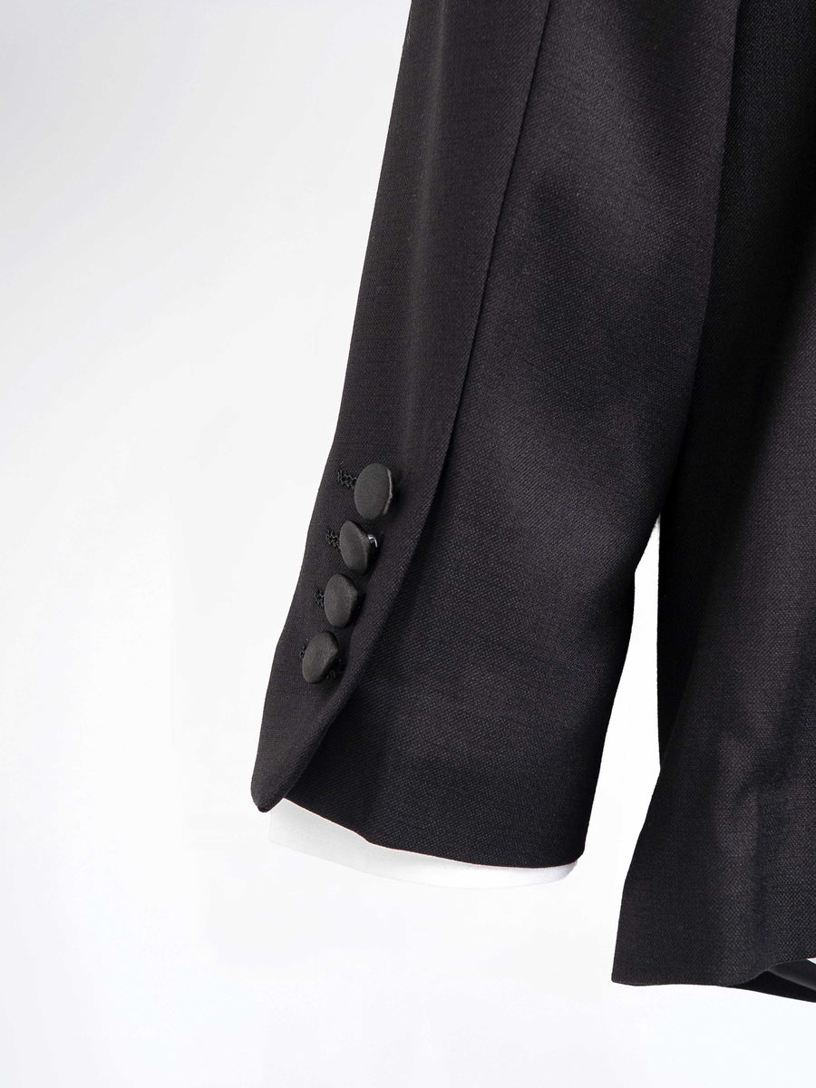 Black men's suit jacket sleeve with four buttons, formal wear detail