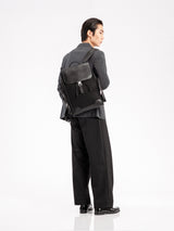 Man in formal suit with black leather backpack, stylish men's apparel and loafers