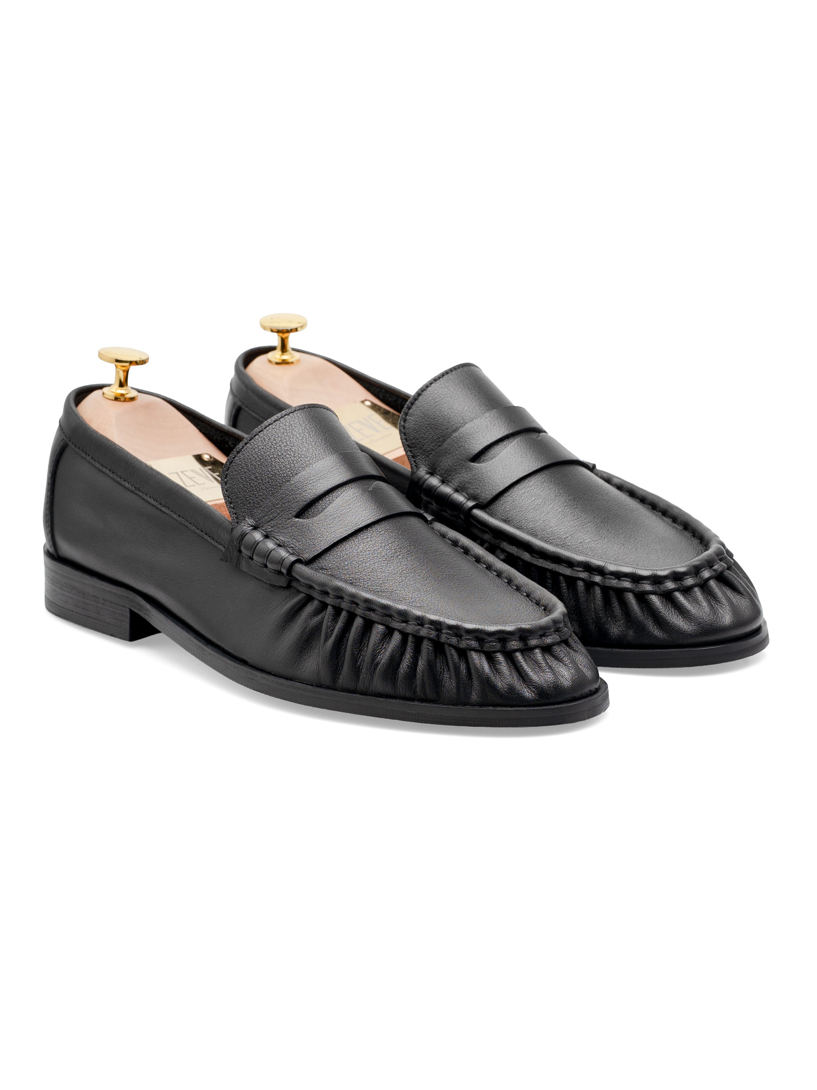 Black leather penny loafers with gold shoe trees, men's formal footwear