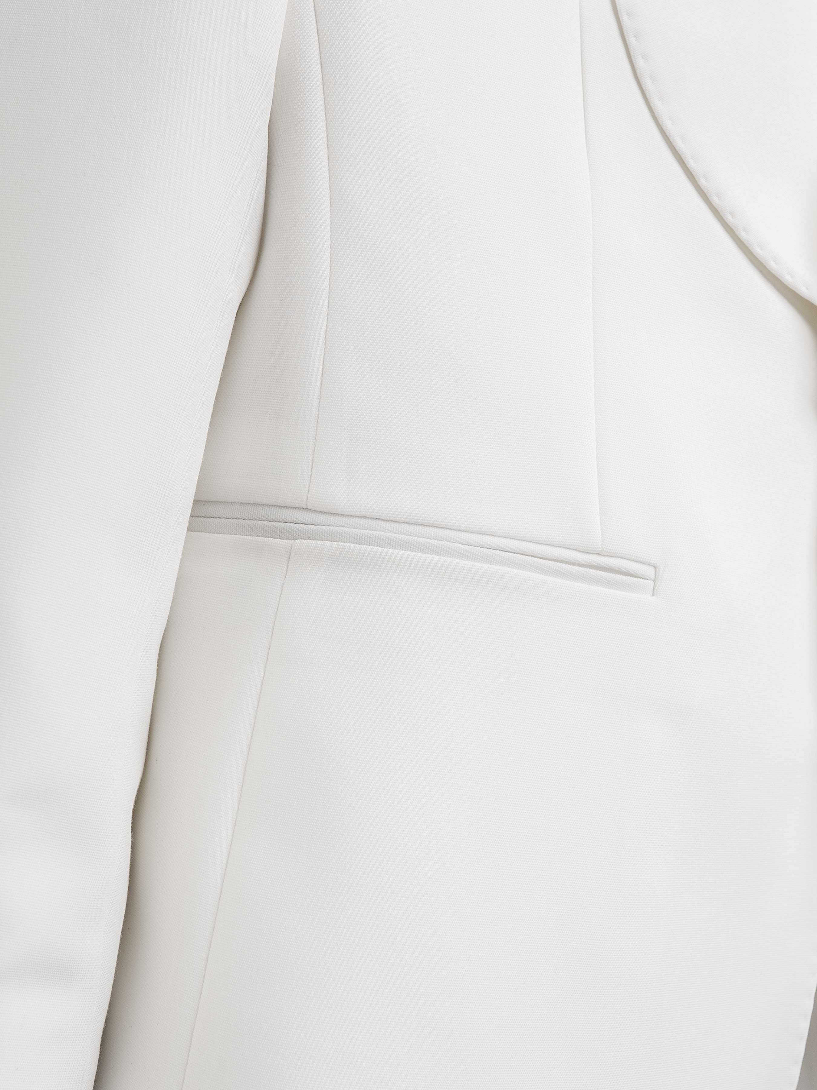 White men's suit jacket close-up showing clean stitching and pocket detail