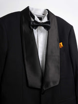 Black tuxedo with satin lapels, bow tie, white dress shirt, and orange pocket square for formal events