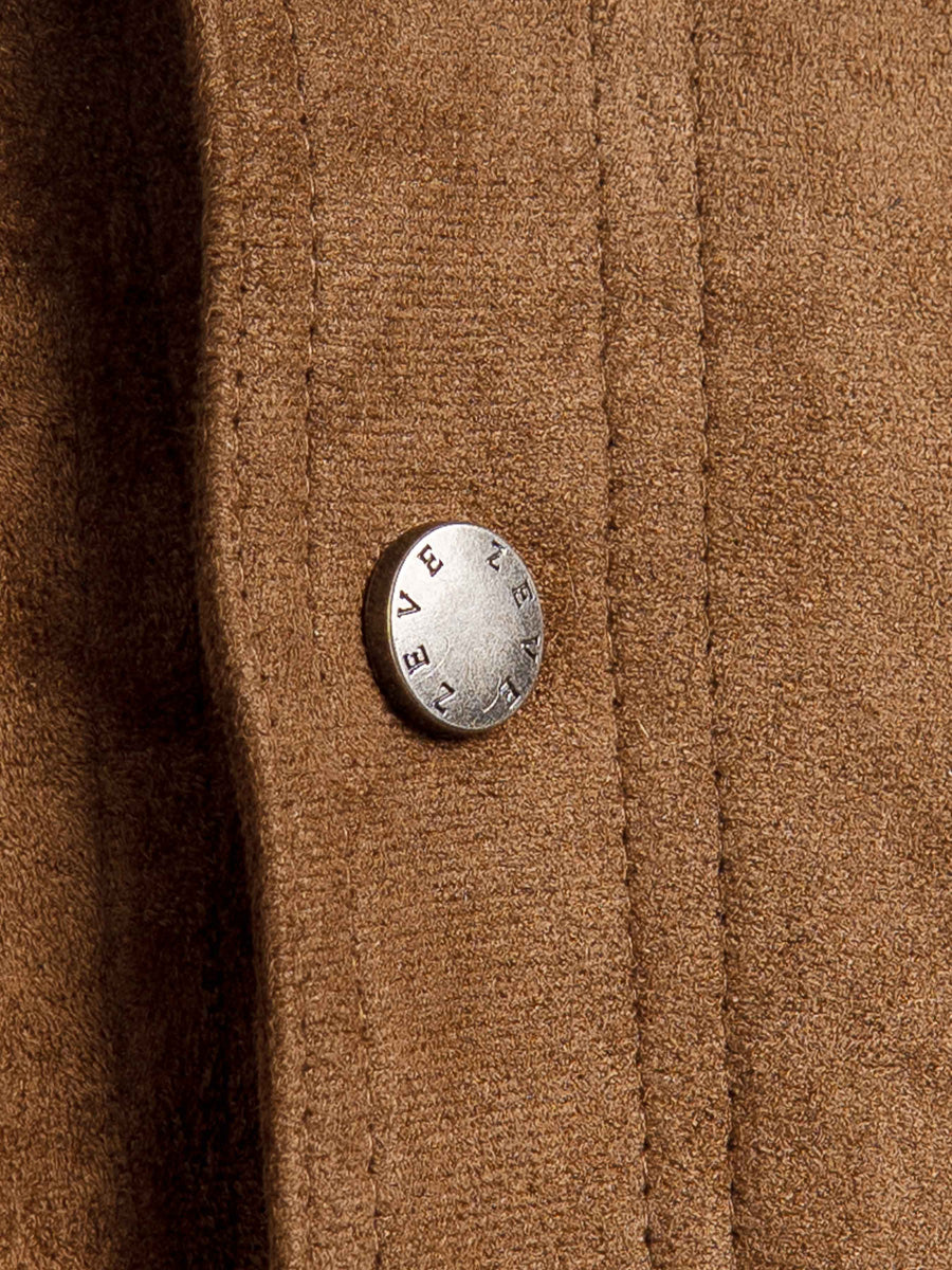 Close-up of a brown wool coat with a branded metal button, showcasing textured fabric and tailored stitching.