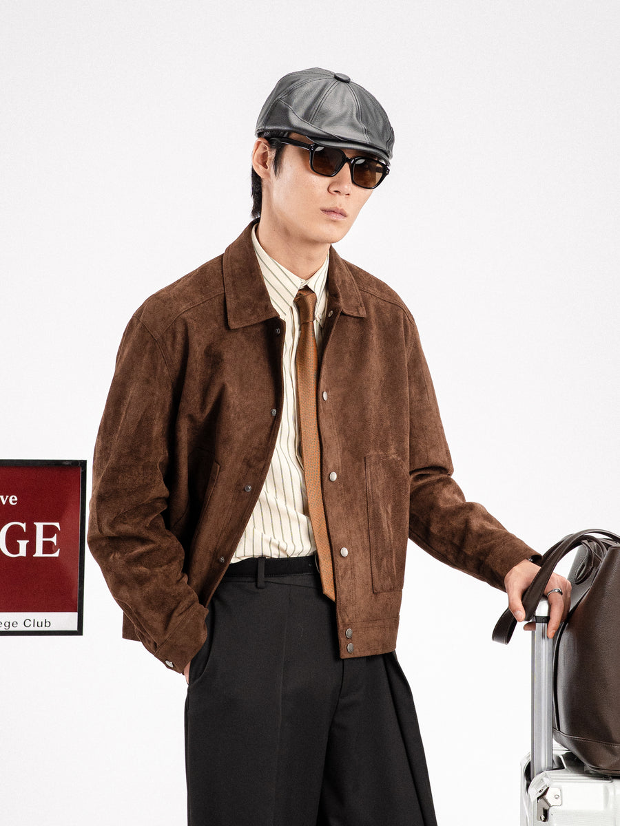 Man in brown suede jacket, striped shirt, tie, and cap with suitcase, stylish men's apparel