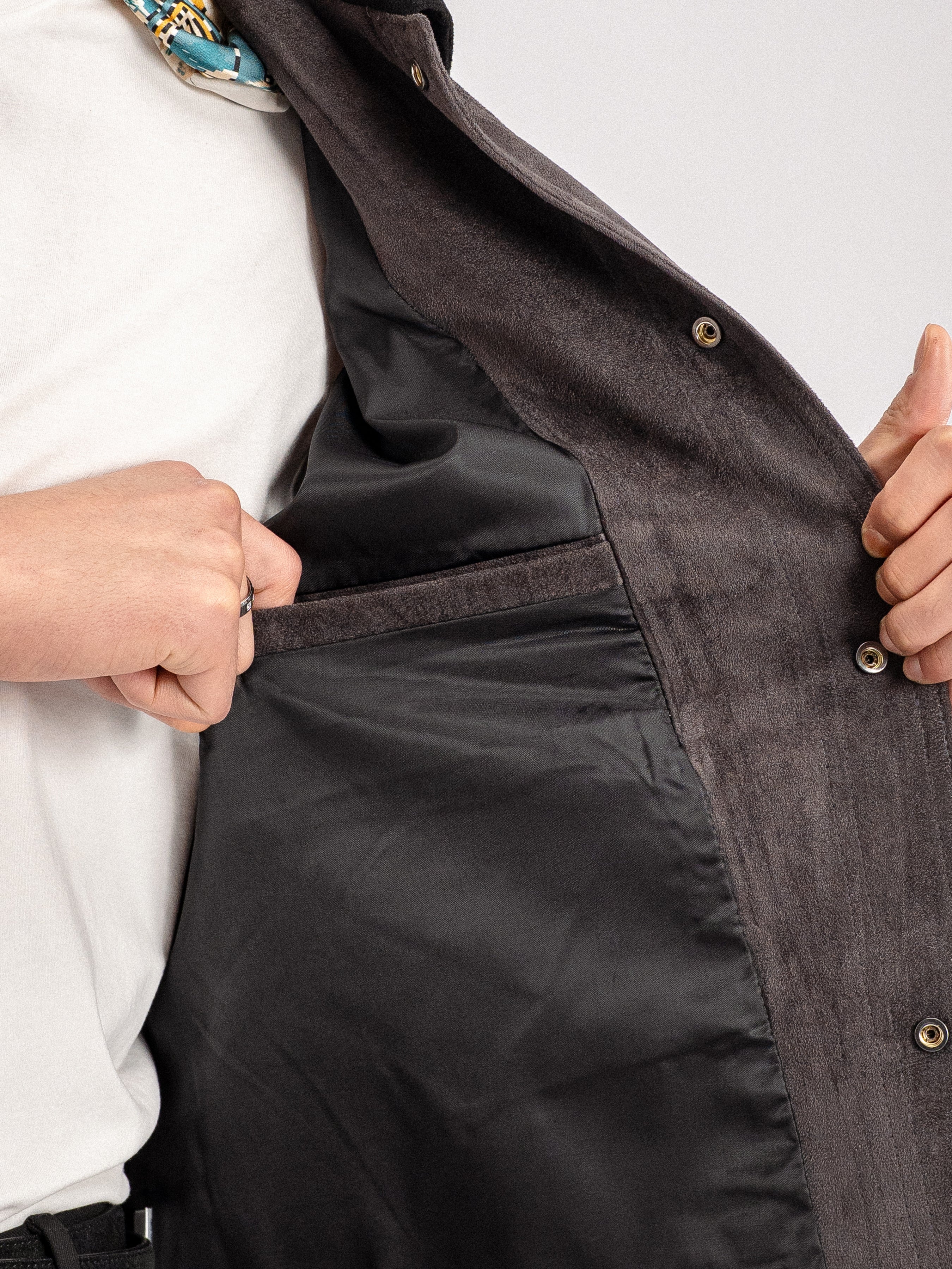 Men's dark gray suede jacket with gold snap buttons, styled with white tee and patterned scarf