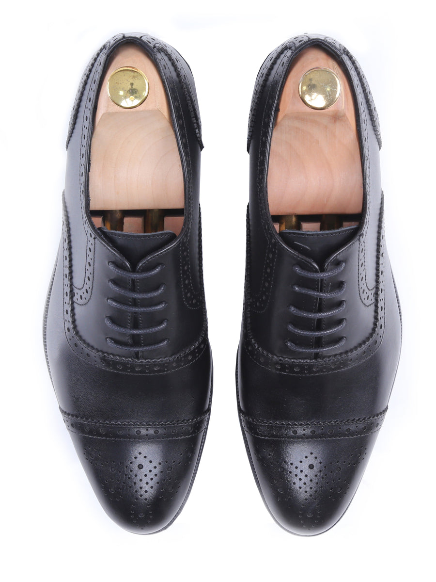 Black leather men's oxford dress shoes with brogue detailing and wooden shoe trees