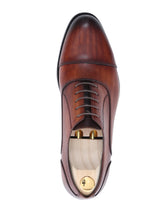 Top view of a cognac tan leather oxford cap toe lace-up men's formal shoe with wooden shoe tree
