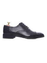Men’s black leather brogue oxford shoe with perforated detailing on a white background
