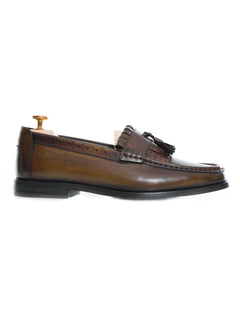 Brown leather tassel loafer with brogue detailing, men's formal shoe on white background