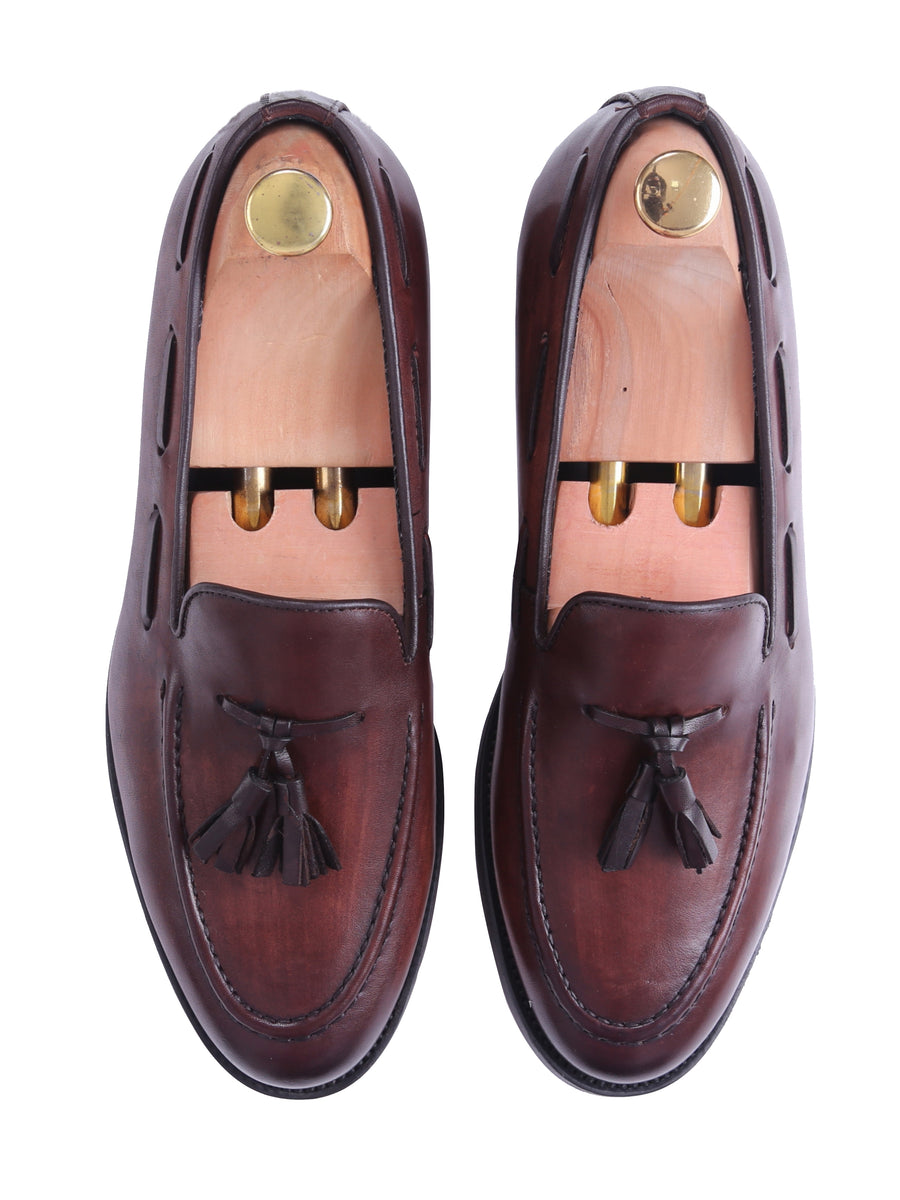 Men's brown leather tassel loafers with wooden shoe trees, formal footwear on white background